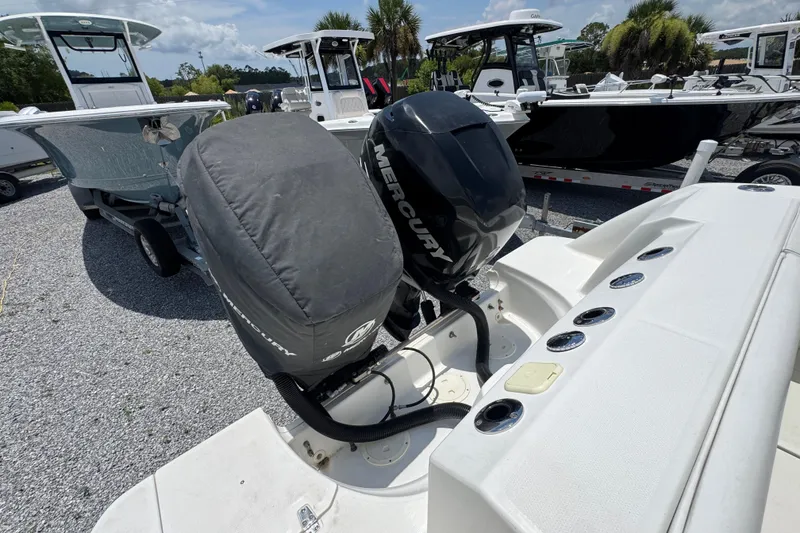 Slide: The Image of 2014 Boston Whaler 250 Outrage with dual Mercury outboard engines, parked on gravel. - 39