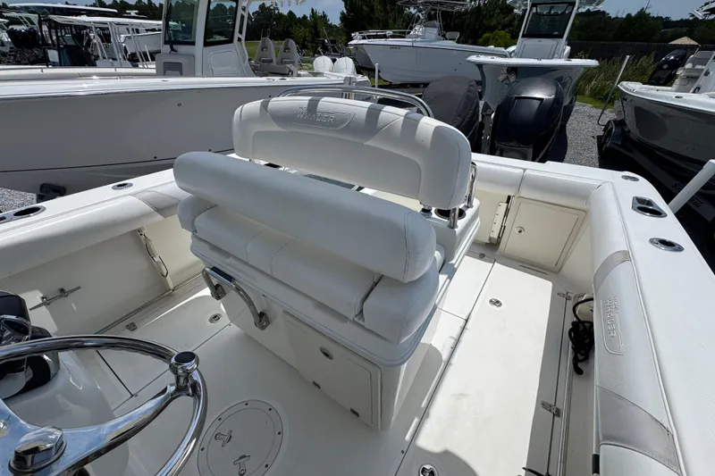 Slide: The Image of 2014 Boston Whaler 250 Outrage boat interior with white seating and steering wheel. - 30