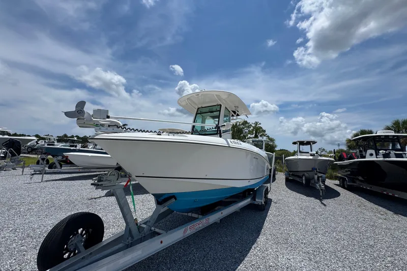 Slide: The Image of 2014 Boston Whaler 250 Outrage boat on trailer under a partly cloudy sky. - 4