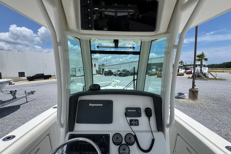 Slide: The Image of 2014 Boston Whaler 250 Outrage helm with Raymarine electronics, parked outdoors. - 28