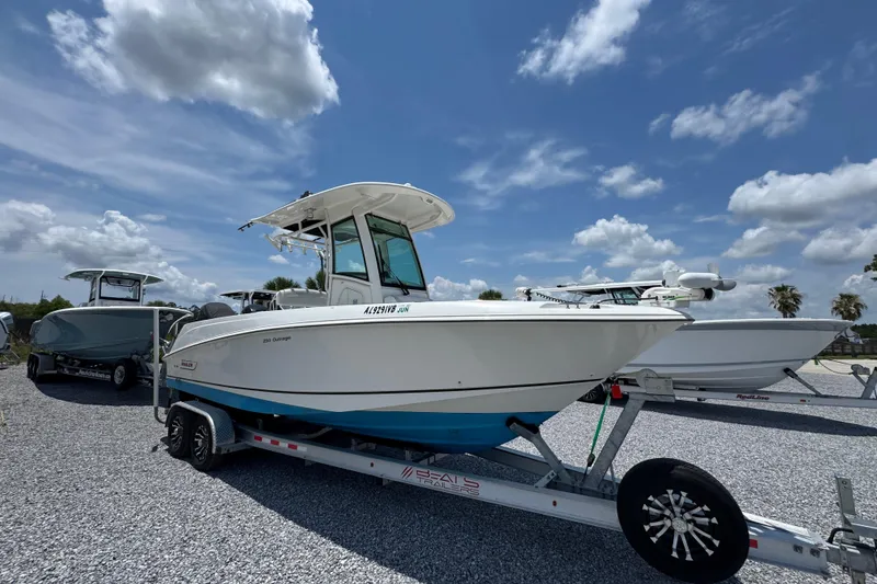 Slide: The Image of 2014 Boston Whaler 250 Outrage boat on trailer under a blue sky. - 8