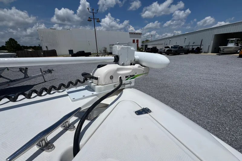 Slide: The Image of 2014 Boston Whaler 250 Outrage with Rhodan trolling motor, parked outdoors under a cloudy sky. - 19