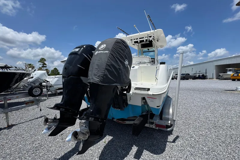 Slide: The Image of 2014 Boston Whaler 250 Outrage with dual Mercury outboard engines on a gravel lot. - 12