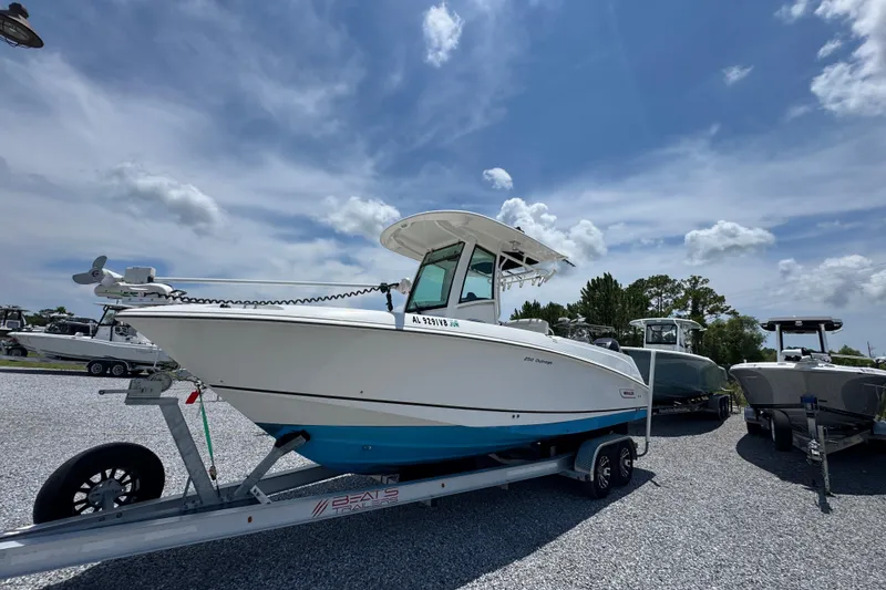 Slide: The Image of 2014 Boston Whaler 250 Outrage boat on trailer under a clear blue sky. - 3