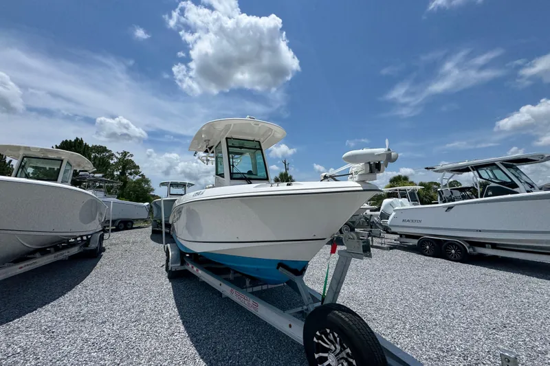 Slide: The Image of 2014 Boston Whaler 250 Outrage boat on trailer under blue sky. - 7