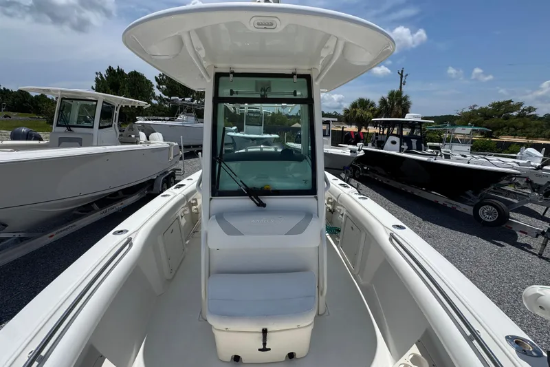 Slide: The Image of 2014 Boston Whaler 250 Outrage boat, white exterior, docked with other boats, sunny day. - 22