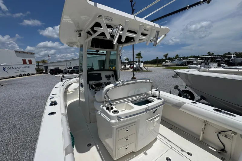 Slide: The Image of 2014 Boston Whaler 250 Outrage boat interior with helm and seating, parked at a marina. - 33