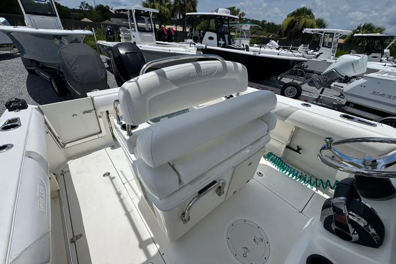 Slide: The Image of 2014 Boston Whaler 250 Outrage boat interior with white seating and steering wheel. - 32