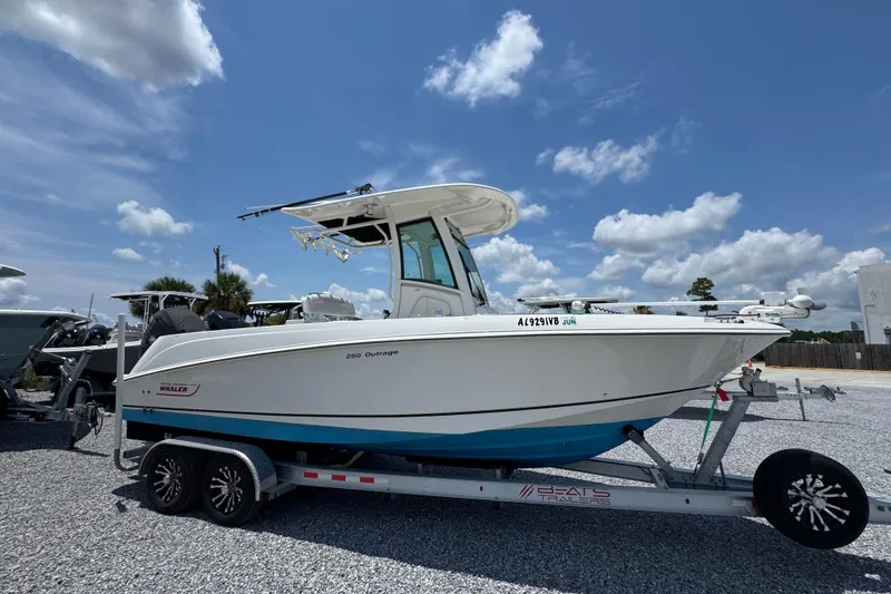 Slide: The Image of 2014 Boston Whaler 250 Outrage boat on trailer under a clear blue sky. - 9
