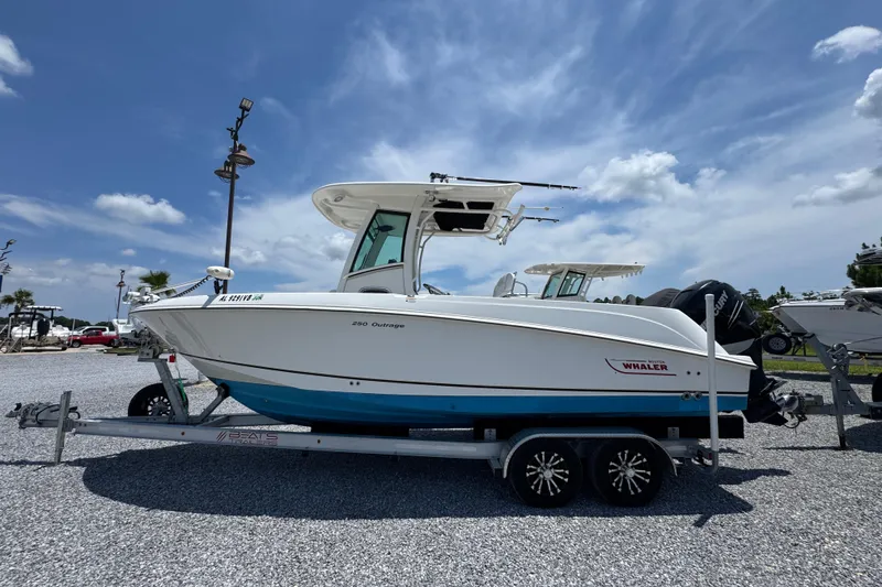 The Image of 2014 Boston Whaler 250 Outrage boat on trailer under clear blue sky. - 1