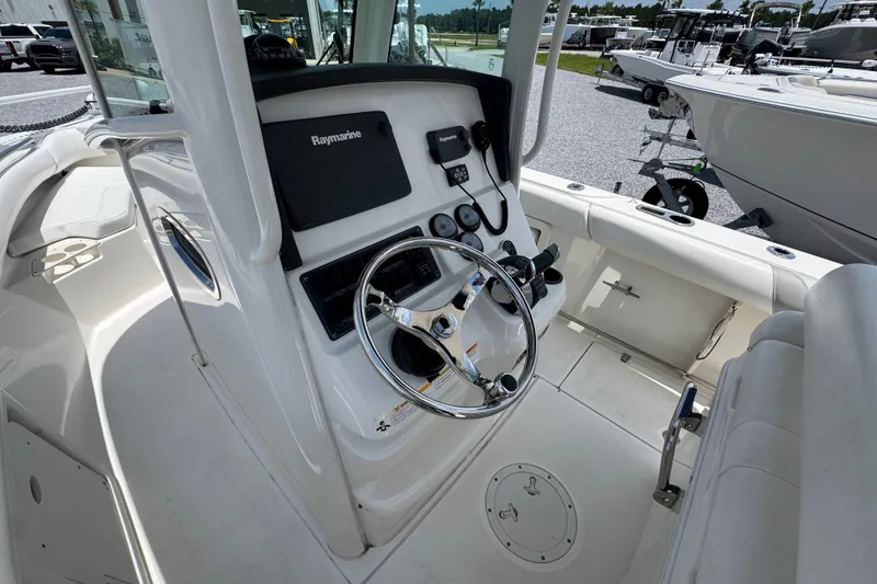 Slide: The Image of 2014 Boston Whaler 250 Outrage boat cockpit with steering wheel and Raymarine electronics. - 26