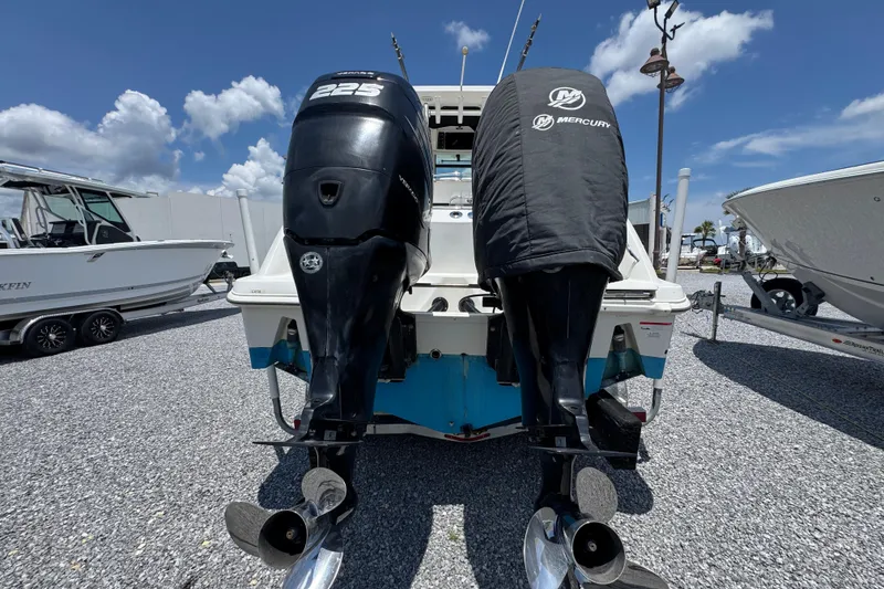 Slide: The Image of 2014 Boston Whaler 250 Outrage with dual Mercury outboard engines, parked on gravel. - 13