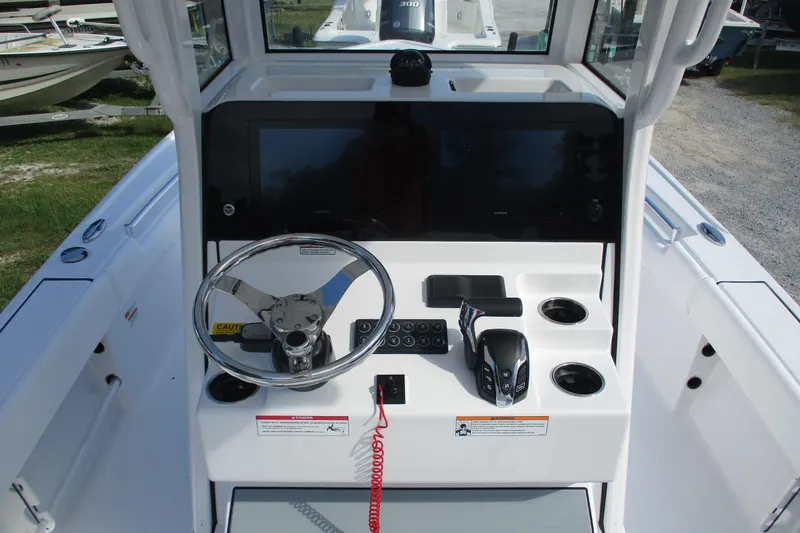 Slide: The Image of 2026 Sportsman Masters 247OE Bay Boat helm with steering wheel and control panel. - 10
