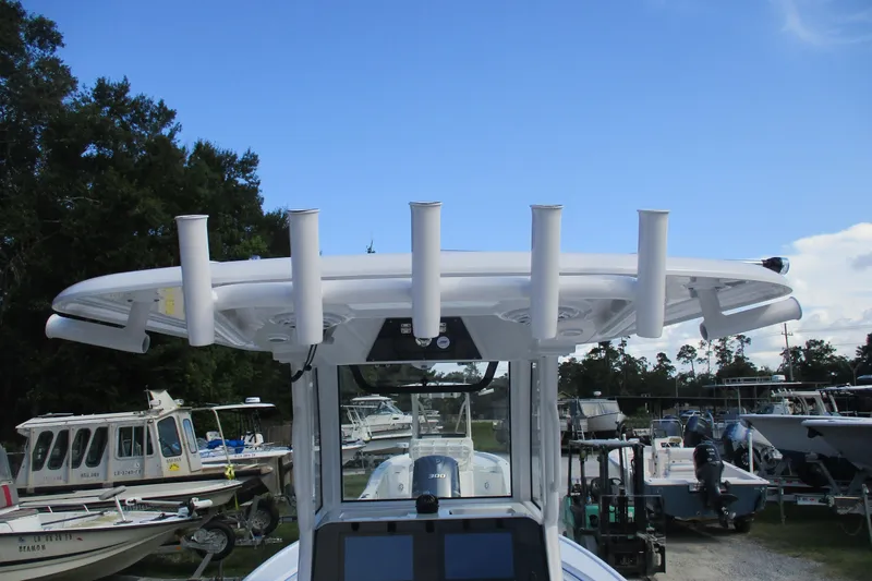 Slide: The Image of 2026 Sportsman Masters 247OE Bay Boat with rod holders, docked under clear blue sky. - 15