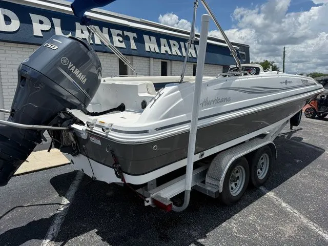 Slide: The Image of A gray and white boat on a trailer in front of a building labeled "Planet Marine." - 4