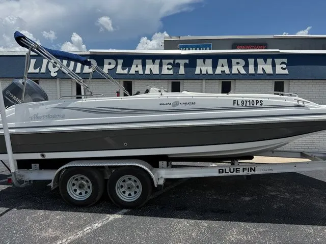 Slide: The Image of A 2014 Hurricane 201 Sun Deck Sport boat on a trailer in front of a marine store. - 3