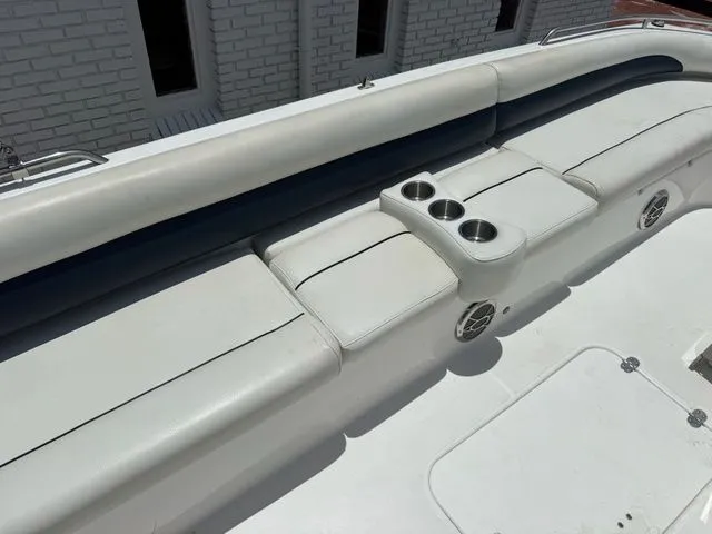 Slide: The Image of Seating area with white cushions and cup holders on a 2014 Hurricane 201 Sun Deck Sport. - 12
