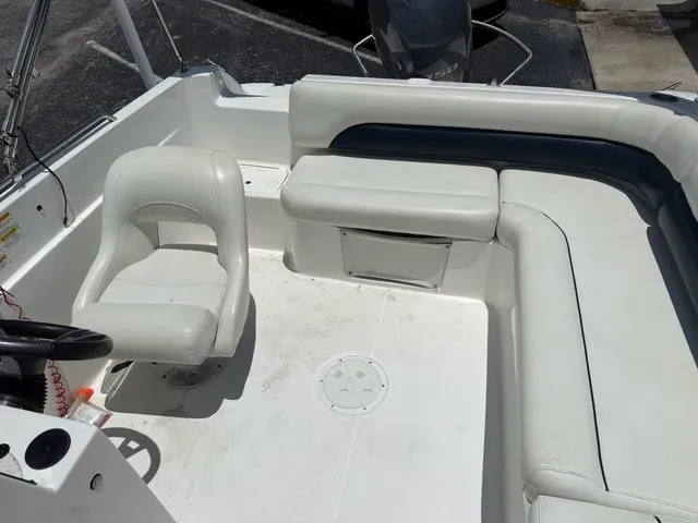 Slide: The Image of The image shows the cockpit of a 2014 Hurricane 201 Sun Deck Sport boat with white seating. - 10