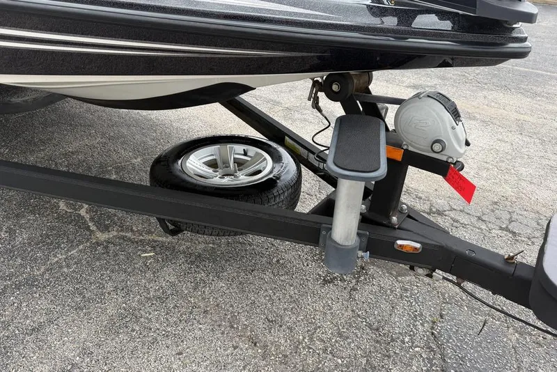 Slide: The Image of 2014 Skeeter FX210 boat trailer with spare tire on asphalt. - 8