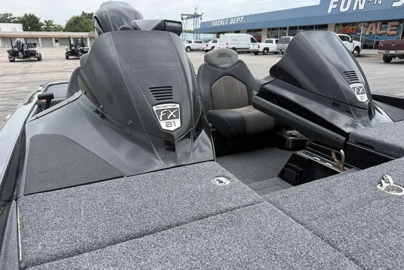 Slide: The Image of 2014 Skeeter FX210 boat interior with dual consoles and seating in a dealership lot. - 15