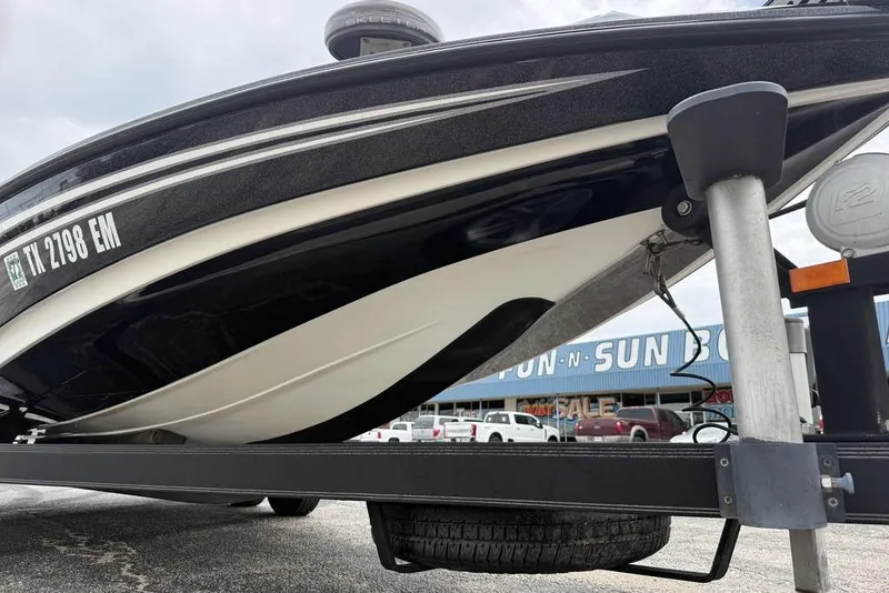 Slide: The Image of 2014 Skeeter FX210 boat on trailer, displayed at dealership with visible registration number. - 4
