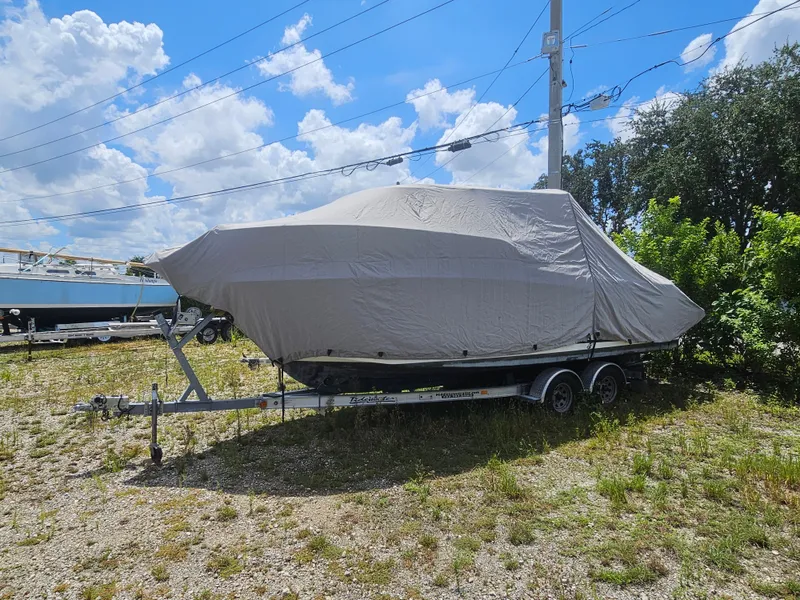 Slide: The Image of A 2020 Jeanneau NC 795 boat is covered on a trailer, parked outdoors. - 18