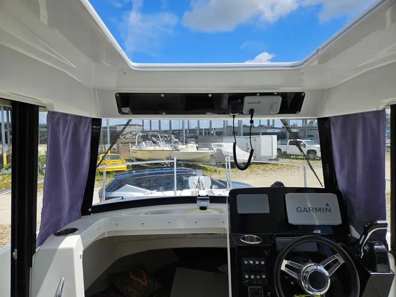 Slide: The Image of Interior view of a Jeanneau NC 795 boat with Garmin navigation system, parked on land. - 12