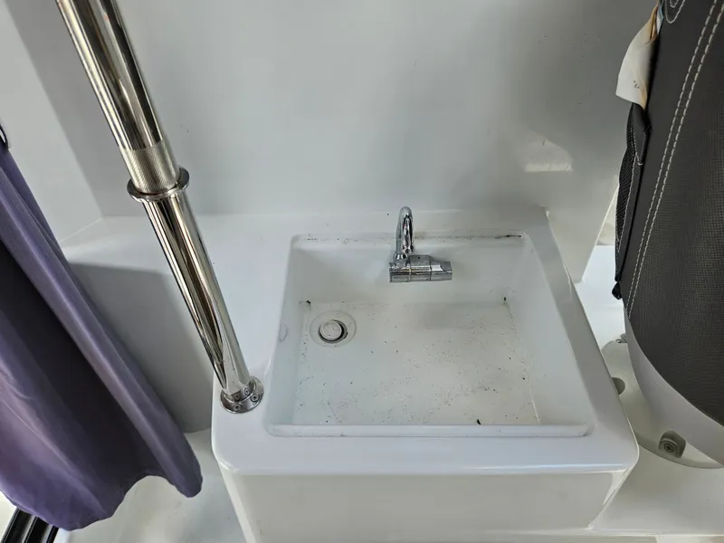 Slide: The Image of A small sink with a faucet on a boat, surrounded by white surfaces. - 10