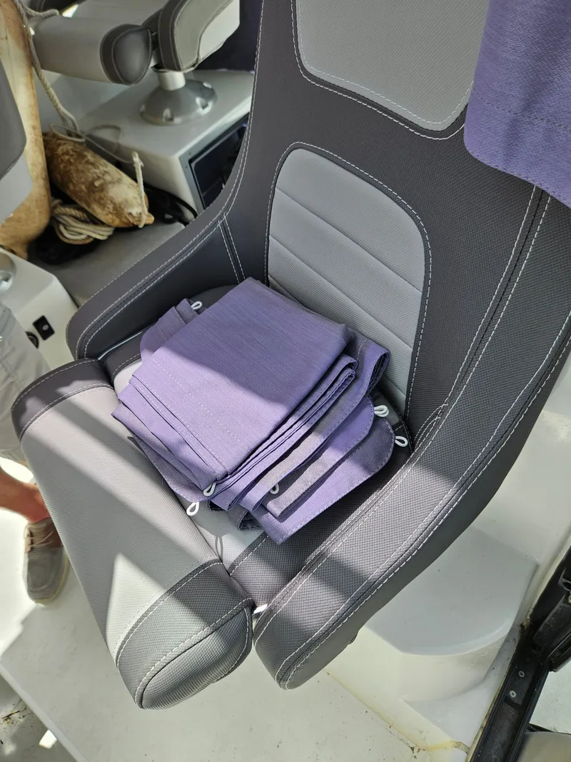 Slide: The Image of A gray boat seat with purple towels on it. - 13