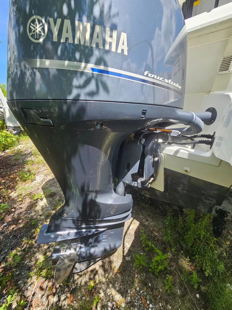 Slide: The Image of A Yamaha four-stroke outboard motor on a boat, surrounded by plants and gravel. - 17