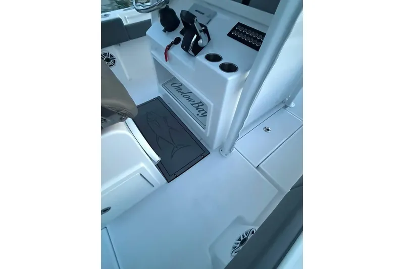 Slide: The Image of 2023 Onslow Bay 27 Offshore Edition boat interior with console and seating area. - 10