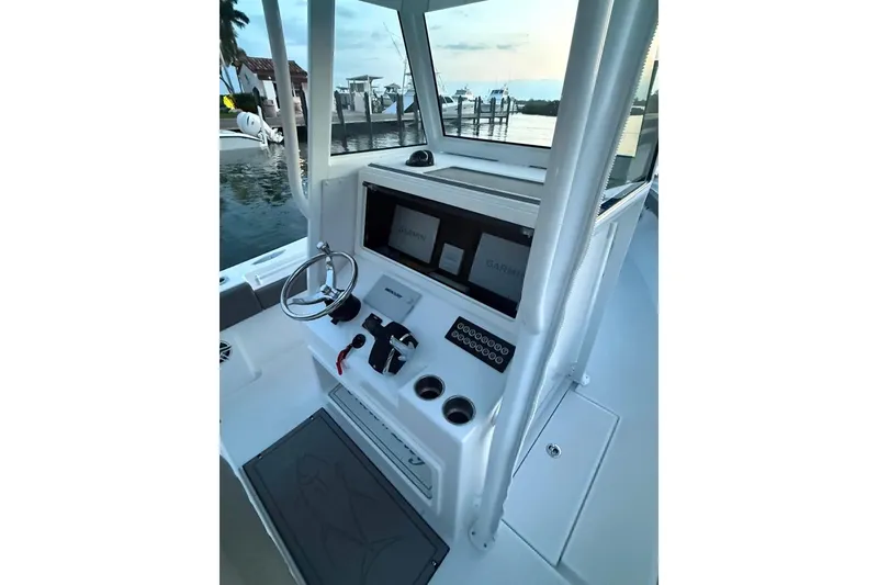 Slide: The Image of 2023 Onslow Bay 27 Offshore Edition boat console with steering wheel and navigation screens. - 9