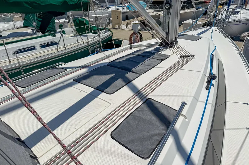 Slide: The Image of 2014 Bavaria Cruiser 37 sailboat deck with rigging and sun pads in marina. - 59