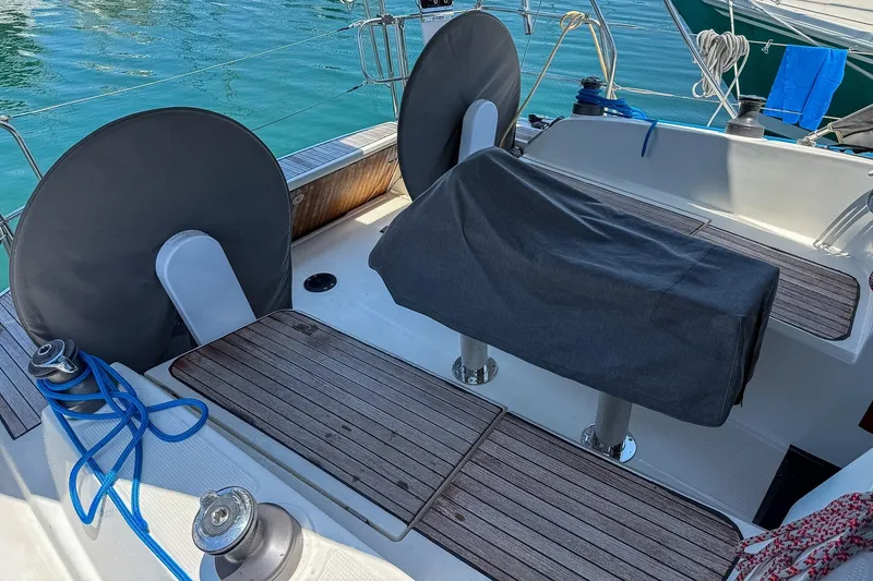Slide: The Image of Cockpit of 2014 Bavaria Cruiser 37 sailboat with covered steering wheels and teak flooring. - 62