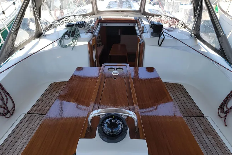 Slide: The Image of The cockpit of a 2014 Bavaria Cruiser 37 with a glossy wooden table and navigation compass. - 21