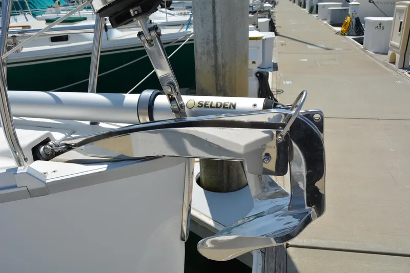 Slide: The Image of A shiny anchor is attached to a sailboat docked at a marina. - 41