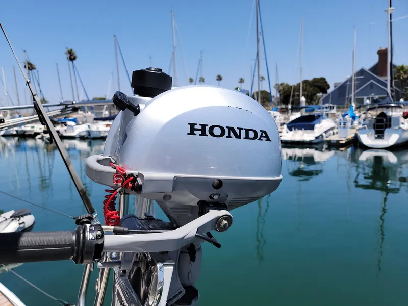Slide: The Image of A Honda outboard motor is attached to a sailboat docked in a marina. - 30