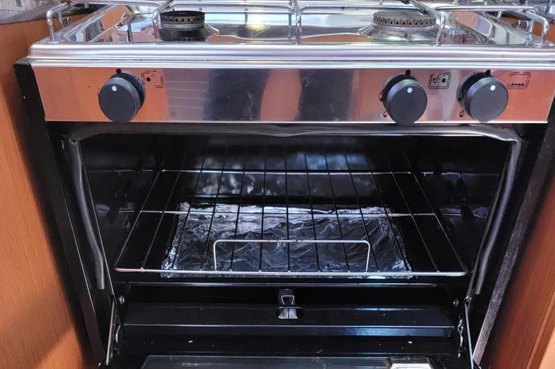 Slide: The Image of An oven with two gas burners and an oven below, set in a wooden kitchen. - 12