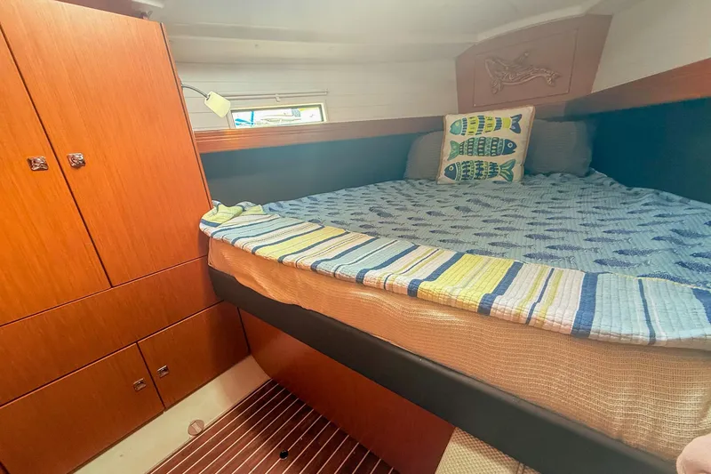 Slide: The Image of Cozy cabin interior of 2014 Bavaria Cruiser 37 yacht with wooden cabinetry and nautical bedding. - 13