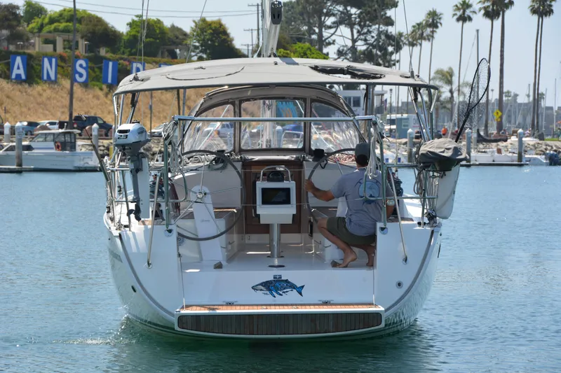 Slide: The Image of A 2014 Bavaria Cruiser 37 entering a harbor. A person is seated at the helm. - 43