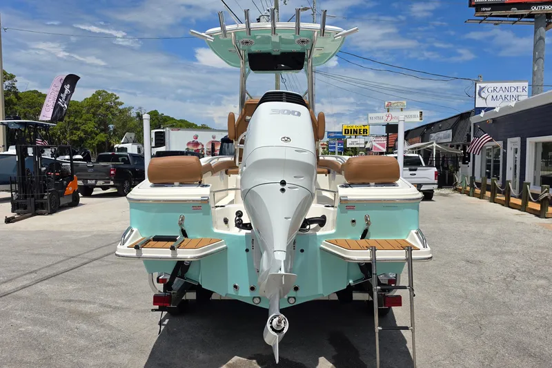 Slide: The Image of 2026 Pioneer 222 Sportfish boat with outboard motor, parked outdoors on a sunny day. - 4