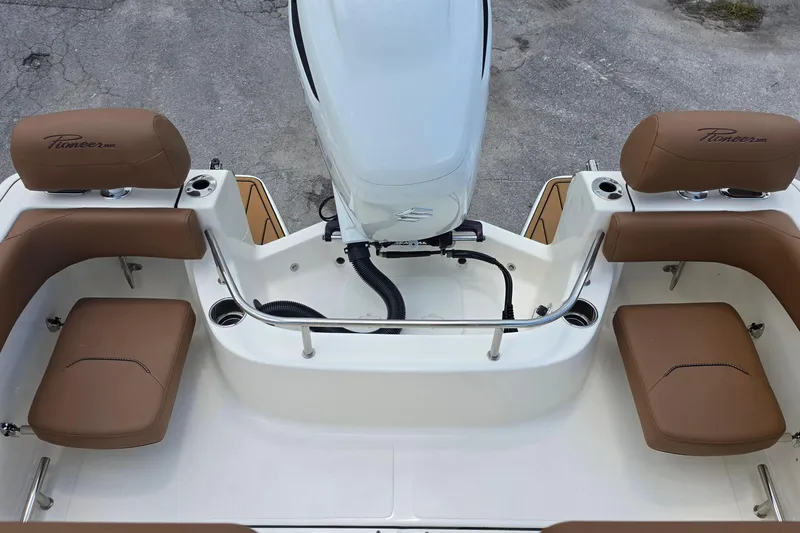 Slide: The Image of 2026 Pioneer 222 Sportfish boat interior with brown seating and outboard motor. - 14