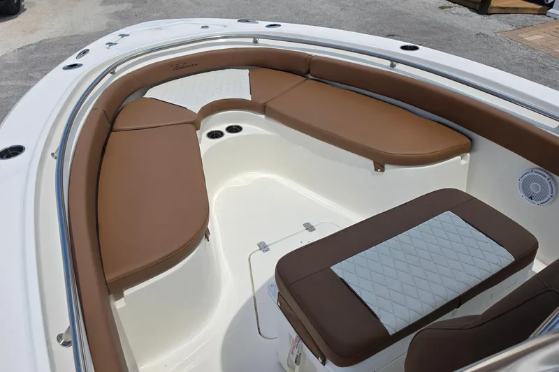 Slide: The Image of 2026 Pioneer 222 Sportfish boat interior with brown cushioned seating and white accents. - 10