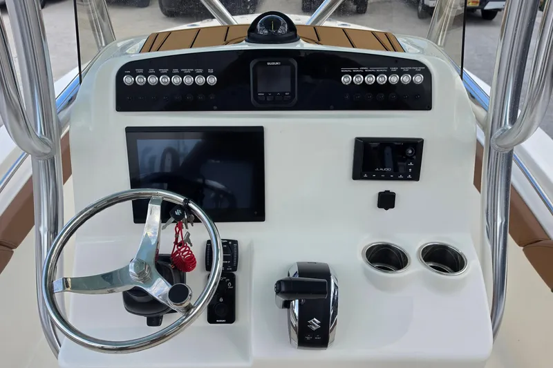 Slide: The Image of 2026 Pioneer 222 Sportfish boat dashboard with steering wheel, controls, and display screens. - 9