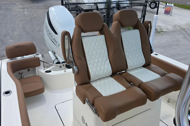 Slide: The Image of 2026 Pioneer 222 Sportfish boat seats with brown and white upholstery, Suzuki engine visible. - 12