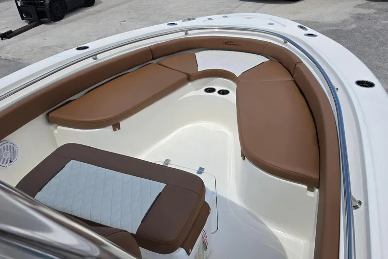 Slide: The Image of 2026 Pioneer 222 Sportfish boat interior with brown cushioned seating and white accents. - 11