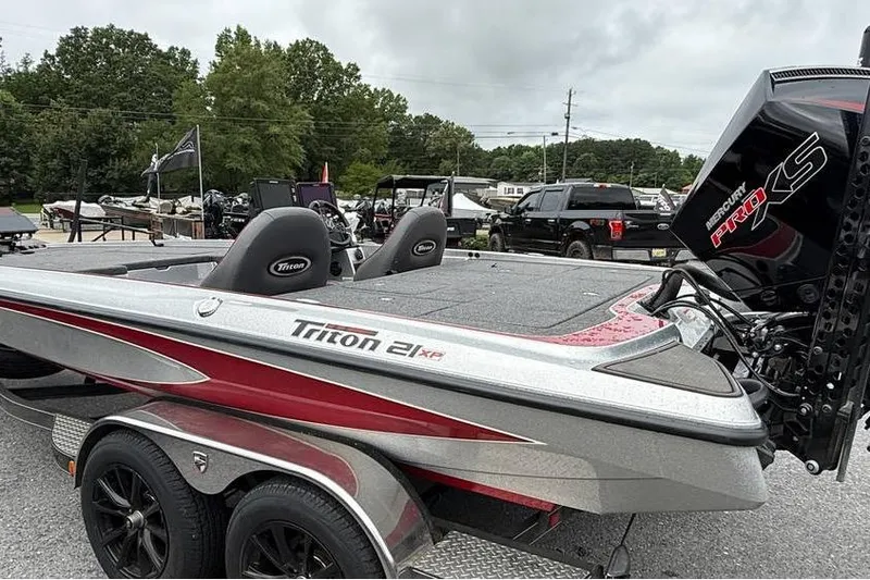 Slide: The Image of 2024 Triton 20XP Patriot boat with Mercury Pro XS engine, parked outdoors. - 1