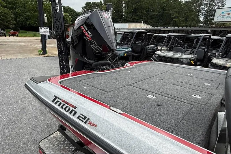 Slide: The Image of 2024 Triton 20XP Patriot boat with powerful engine, parked outdoors. - 98