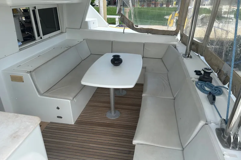 Slide: The Image of Spacious seating area on a 2010 Lagoon 440 catamaran with a central table and cushions. - 66