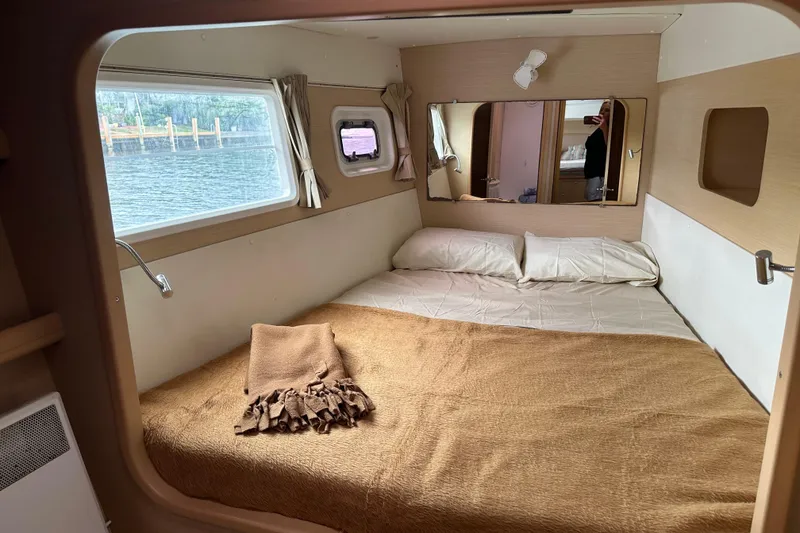 Slide: The Image of Cozy cabin interior of 2010 Lagoon 440 catamaran with bed, window, and mirror. - 61